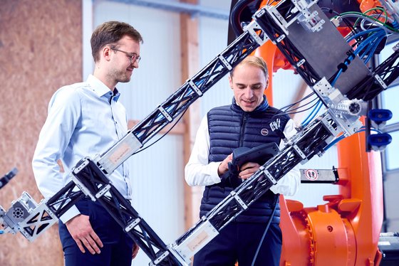Christian Dorer und Tobias Weiser im IKR mit einem Industrieroboter.