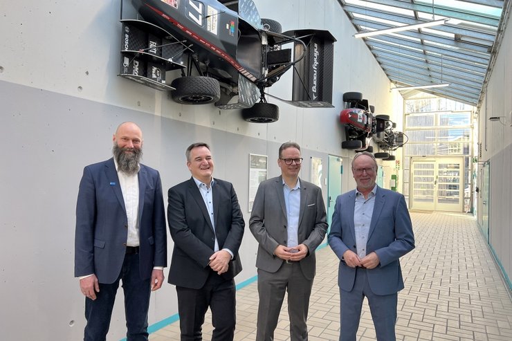 Neu gestalteter Gang der Maschinenhalle an der Fakultät Maschinenbau der Hochschule Kempten – v. l. n. r.: Prof. Dr. Martin Schirra, Dekan der Fakultät Maschinenbau, Christian Könitzer, Vorsitzender des VDI-Bezirksvereins Augsburg, Prof. Dr.-Ing. Gregor Bischoff, Faculty Advisor des Infinity-Racing-Teams sowie Hochschulpräsident Prof. Dr. Wolfgang Hauke. An der Wand hängen drei Rennwagen.